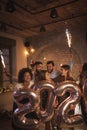 Friends waving with sparklers and holding 2020 balloons celebrating New Year Royalty Free Stock Photo