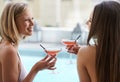 Friends, women and bonding with alcohol at pool, outdoors and drinking wine on vacation. People, communication and Royalty Free Stock Photo