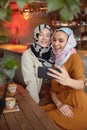 Friends. Women In Hijab Taking Selfie. Women Meeting In Cafe. Smiling Muslim Female Having Fun.