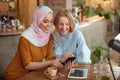 Friends. Young Girls In Cafe. Smiling Women Looking At Smartphone Screen. Royalty Free Stock Photo