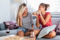 Friendship, food and leisure concept - Two happy female friends eating pizza and drinking wine at home. Girlfriends having fun Royalty Free Stock Photo