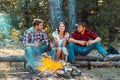 Friendship and leisure concept. Friends hikers watching fire together on camp. Weekend. Good day for spring picnic in