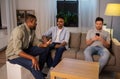 Happy male friends talking at home at night Royalty Free Stock Photo