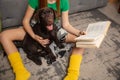 Happy little girl reading book with beloved dog. Lifestyle concept Royalty Free Stock Photo