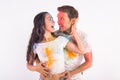 Friendship, love, festival of holi, people concept - young couple playing with colors at the festival of holi on white Royalty Free Stock Photo