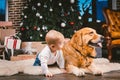 Friendship man child and dog pet. Theme Christmas New Year Winter Holidays. Baby boy on the floor decorated tree and best friend