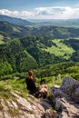 Friendship between man and dog.. Young girl siitting on top of the hill with her dog Bandog and looking on mountains Royalty Free Stock Photo