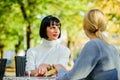 Friendship meeting. Friendship or rivalry. Girls friends drink coffee talk. Conversation of two women cafe terrace