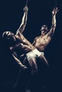 Friendship of men do gymnastic. Twins men with muscular body on rope. Circus gymnasts at pilates or yoga training