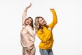 friendship, people and appiness concept. Two happy dancing girls on white background