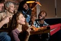 friendship, people, entertainment and junk food concept - happy friends eating pizza and watching movie or tv series at