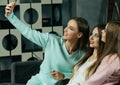 Friendship, people and technology concept - happy friends or teenage girls with smartphone taking selfie at home Royalty Free Stock Photo