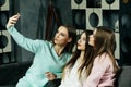 friendship, people and technology concept - happy friends or teenage girls with smartphone taking selfie at home Royalty Free Stock Photo