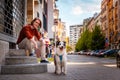 Friendship with pet. Young handsome Caucasian man sitting on steps posing with pure breed aussie dog Royalty Free Stock Photo