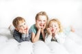 Friendship: three children lie on the bed and make funny faces