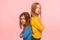 Friendship, togetherness and support. Two wonderful preschool girls standing back to back, looking at camera Royalty Free Stock Photo