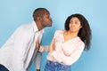 Friendzone concept. Disgusted black young woman avoiding unwanted kiss from middle aged man Royalty Free Stock Photo