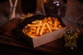 Fries food photo. Street food. Unhealthy tasty grilled french fries in homemade craft box. Closeup with unfocused