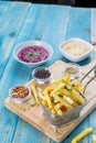 Fries Potato in Basket with Hommos and Red Hommos, Fried Potato with Spices and Arabic Hommos / Hummus / Hummus. On Blue Wood