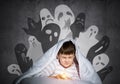 Frightened child with flashlight under blanket Royalty Free Stock Photo