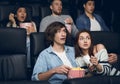 Frightened couple watching thriller on night out in cinema Royalty Free Stock Photo