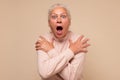 Frightened elderly woman looking surprised and shocked