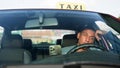 Frightened female passenger getting into a taxi and taxi driver driving quickly. Yellow taxi car roof sign. People, job Royalty Free Stock Photo