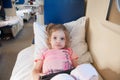 Frightened girl lying on the bed with a tablet in the car with reserved seats