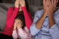 Frightened Hispanic Family Sitting On Sofa And Watching TV Royalty Free Stock Photo