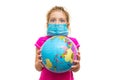 Frightened little girl in a medical mask holds a globe in her hands. Surprised baby eating isolated on a white background. Childre Royalty Free Stock Photo