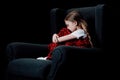 Frightened, lonely child sitting in armchair
