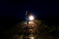 Frightened lonely running female silhouette on the night country road running away from pursuers on the car in the light of headli Royalty Free Stock Photo