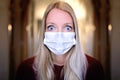 A Frightened Looking Caucasian Woman with Big Blue Eyes and Wearing a Medical Sugical Mask