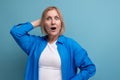 frightened middle-aged woman in a beautiful shirt on a blue background Royalty Free Stock Photo