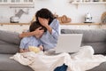 Mom and kid son with bowl of popcorn watching scary movie closing their eyes sitting on sofa at home Royalty Free Stock Photo