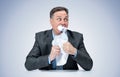 A frightened official in a dark suit eats the evidence paper, on a light blue background. Royalty Free Stock Photo