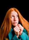 Frightened redhead girl isolated on black background