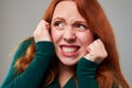 Frightened redhead woman defending herself with hands