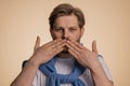 Frightened scared man closing his mouth with hand, gestures no, refusing to tell terrible secret Royalty Free Stock Photo