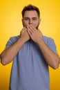 Frightened scared man closing his mouth with hand, gestures no, refusing to tell terrible secret Royalty Free Stock Photo