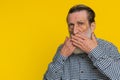 Frightened senior man closing mouth with hands refusing to tell terrible secret, unbelievable truth Royalty Free Stock Photo