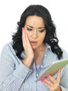 Frightened Shocked Concerned Young Woman Holding a Wireless Tablet Royalty Free Stock Photo