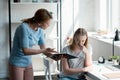 frightened teen daughter sitting on chair while her mother yelling