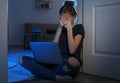 Frightened teenage girl with laptop on floor. Danger of internet