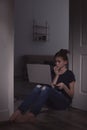 Frightened teenage girl with laptop on floor. Danger of internet