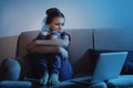 Frightened teenage girl with laptop on sofa. Danger of internet Royalty Free Stock Photo