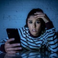 Worried unhappy young woman suffering from cyberbullying and harassment online by mobile phone