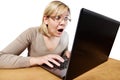 Frightened woman with glasses looking at laptop Royalty Free Stock Photo