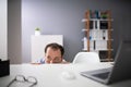 Afraid Businessman Peeking From The Edge Of Desk In Office Royalty Free Stock Photo