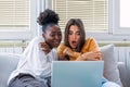 Frightened young women watching movie at home. Girls watching a terror movie on tv sitting on a couch at home. Girlfriends Royalty Free Stock Photo